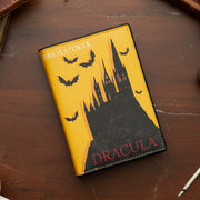 Dracula book purse front view on dark wooden surface showing castle and bat design