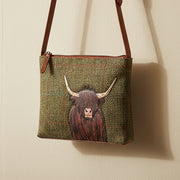 Highland cow crossbody bag in green Harris Tweed hanging on beige wall
