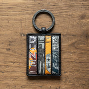 Sci-fi book club keyring showing four book spines on wooden surface