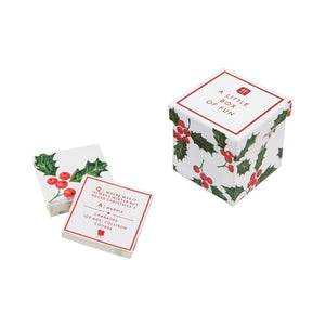 A box of family friendly trivia questions and charades to play around the diner table. The box is open with a couple of cards as an example. 