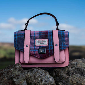Pink leather satchel with a pink and blue Harris Tweed tartan fabric flap with clasp closer.