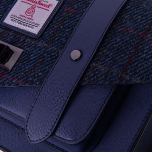 Close-up of the tartan Islander Harris Tweed Navy Over-Check satchel with its faux dark blue leather.