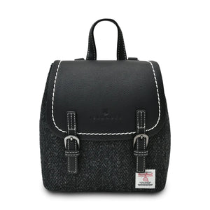 Harris Tweed backpack from Islander. It has a black PU leather top flap with white stitching and finished with Black Herringbone Harris Tweed fabric.