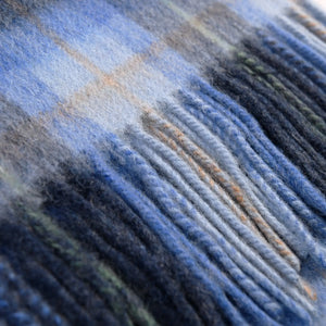 Close up of the tassels that form one end of the blue tartan lambswool scarf.