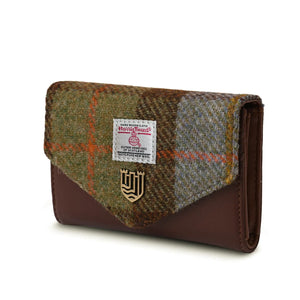 A chestnut and blue Harris tweed purse with a golden clasp and authentication label detail. The tweed is made from 100% wool and handwoven in the Outer Hebrides of Scotland.