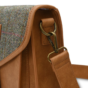 Close up of the attachment for the shoulder strap with the shoulder strap attached. You can see the Harris Tweed fabric. 
