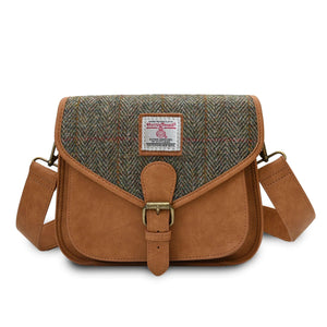 Harris Tweed saddle bag in brown chestnut herringbone pattern with the shoulder strap draped across the back of the bag.