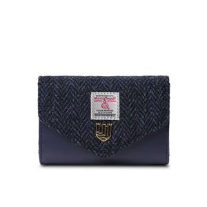 A close-up of a Harris Tweed navy blue herringbone purse with a golden stud closure. The fabric is handwoven in the Outer Hebrides of Scotland, making each purse one-of-a-kind.