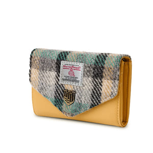 A side view of a Harris Tweed Islander Tartan purse, showing the unique tartan pattern and snap closure. The purse has a sleek and stylish design, perfect for adding a touch of fashion to any outfit. It also features multiple pockets for organization and convenience.
