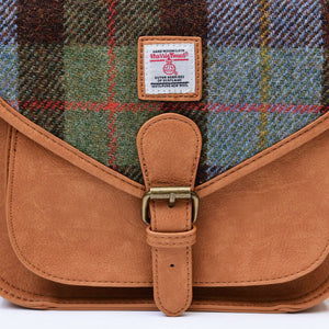 Close-up image of the Harris Tweed fabric and buckle on a Chesnut (Brown) and Blue Tartan Saddle Bag. The fabric is water-resistant and features a unique tartan pattern, while the buckle adds a touch of classic elegance.
