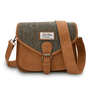 Harris tweed saddle style shoulder bag. You can see the dark brown synthetic leather, buckle closure and adjustable shoulder strap. The front of the back is made from Harris Tweed which is in a chestnut, brown and orange herringbone pattern. On front of the bag is the Harris Tweed label of authenticity