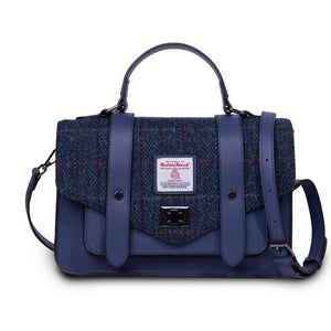 Ladies Harris Tweed satchel style handbag with a navy leather base and a blue and red tartan covering. It has an adjustable shoulder strap and is pictured against a white background. 
