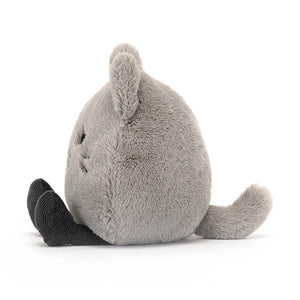 Side view of the Jellycat Amuseabean Kitty a children’s soft toy in the design of a cat. It has little legs sticking out in front. 