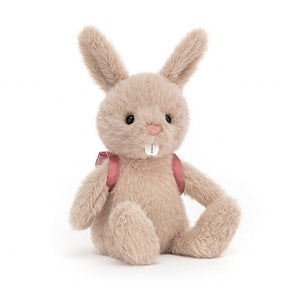 Jellycat Backpack Bunny Rabbit children’s soft toy with long rabbit ears, buck teeth and wearing a pink backpack across her shoulders. 