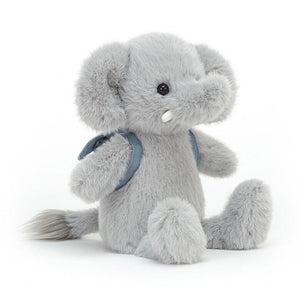 Jellycat Backpack Elephant children’s soft toy. He is covered in fuzzy, soft light grey fur and wears a light blue backpack. 