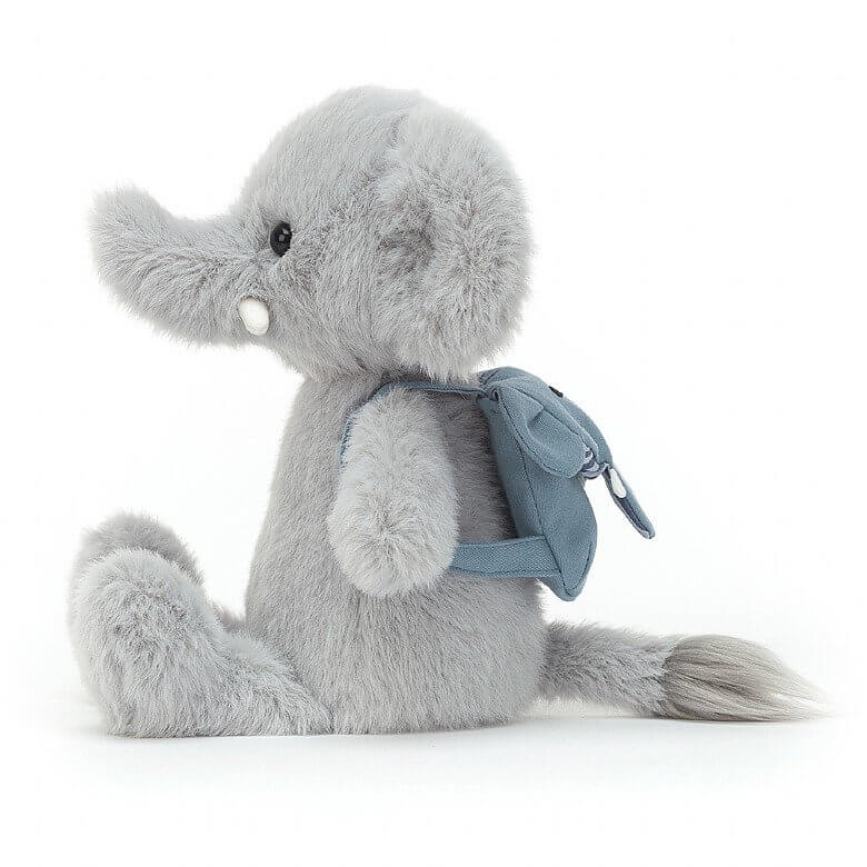 Jellycat Backpack Elephant children’s soft toy from the side. He has his short legs stretched out in front of him and his light blue backpack on his back. 
