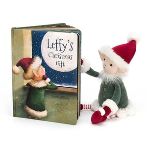An open copy of the Jellycat children’s book Leffy’s Christmas Gift with a soft toy sitting in front. 