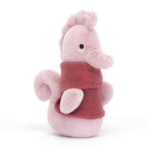 Jellycat Cozy Crew Seahorse children’s soft toy is covered head to toe in soft pink fur and wears a raspberry red knitted jumper.