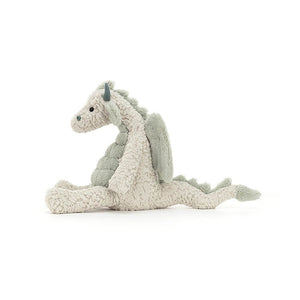 From the side Jellycat Lallagie Dragon childrens soft toy with legs stretched out in front and tail behind. 