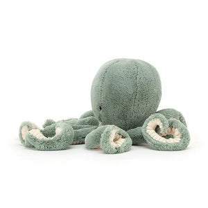 From the side Odyssey Octopus children’s soft toy sits with his long tentacles reaching out in front. 