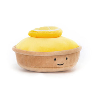 Side view of the Jellycat Patisserie Tart Au Citron or lemon tart. It has a soft lemon slice on the top and a smiley face on the front. Children’s soft toy from Jellycat.