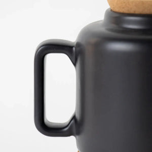 Ceramic teapot in Matt black showing the handle. 
