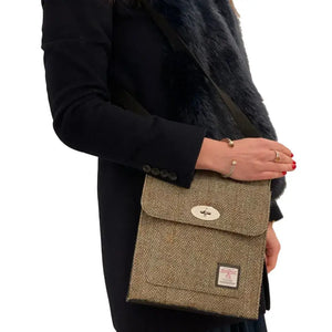 Lady wearing one of the Maccessori Harris Tweed Satchel Shoulder Bags in a brown and green herringbone pattern. 