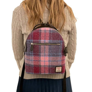 Lady wearing the Maccessori Harris Tweed backpack with a pink and blue check tartan pattern.