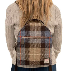 Lady wearing a Maccessori Harris Tweed backpack with a blue and brown check tartan pattern.