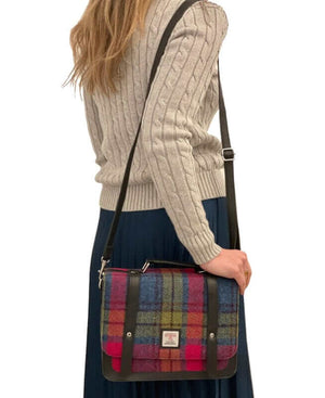 Lady wearing a pink and blue tartan mini messenger shoulder bag made from harris tweed.