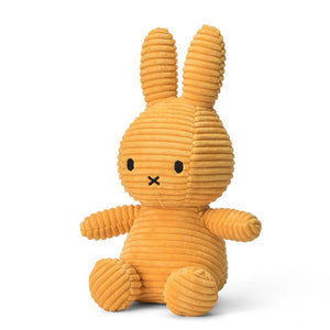 Sitting Miffy bunny children’s plush soft toy from the side. Covered head to toe in yellow fabric.