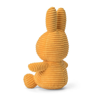 From behind sitting Miffy Bunny children’s plush soft toy covered in yellow corduroy fabric.