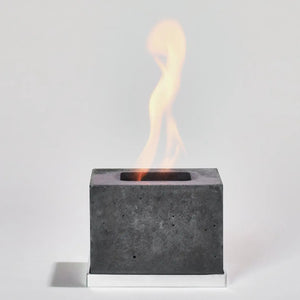 Square cement flikr fireplace on an aluminium base against a white background.