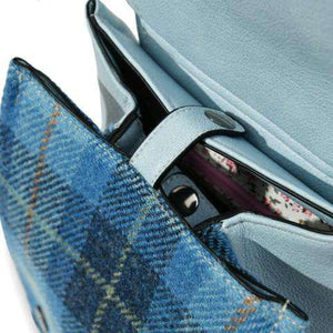 Inside the Islander Harris Tweed Jura Backpack in Blue tartan showing the inside button clasp closure.